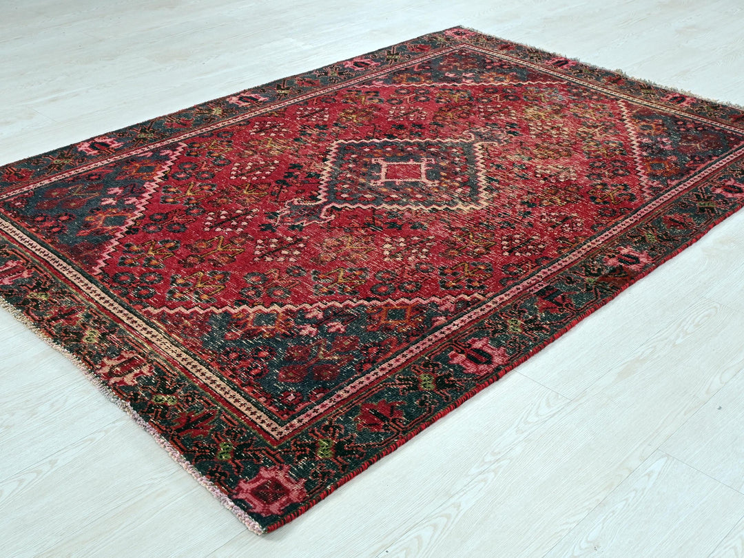 a red and black rug on a white floor