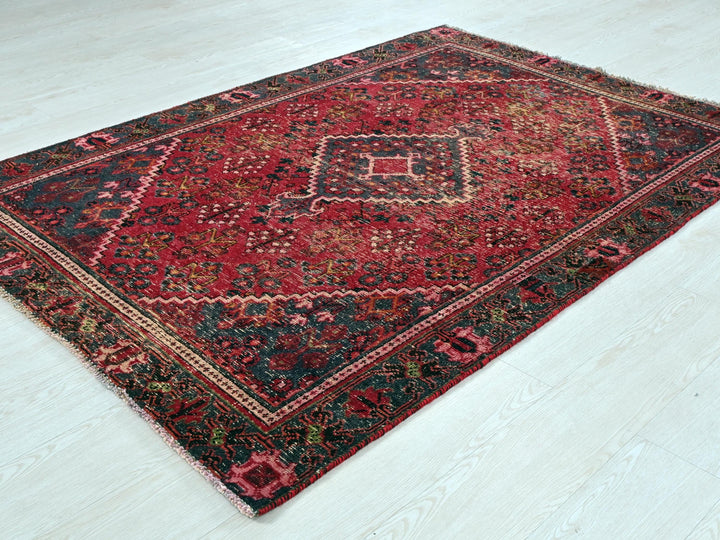 a red and black rug on a white floor