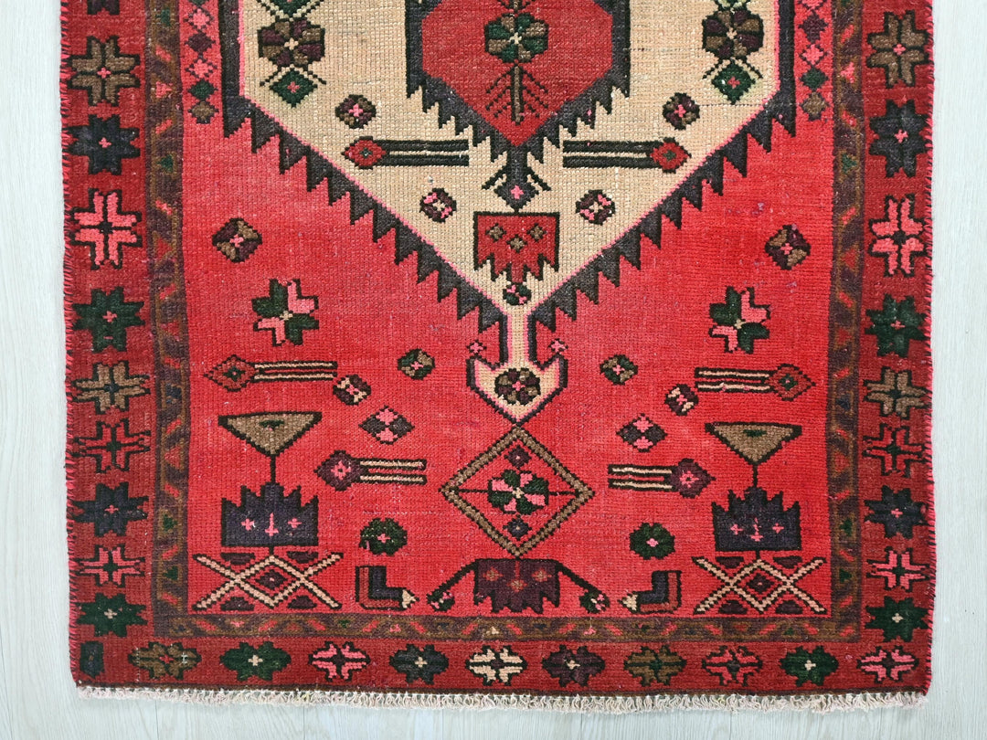 a red rug with a diamond shaped design on it