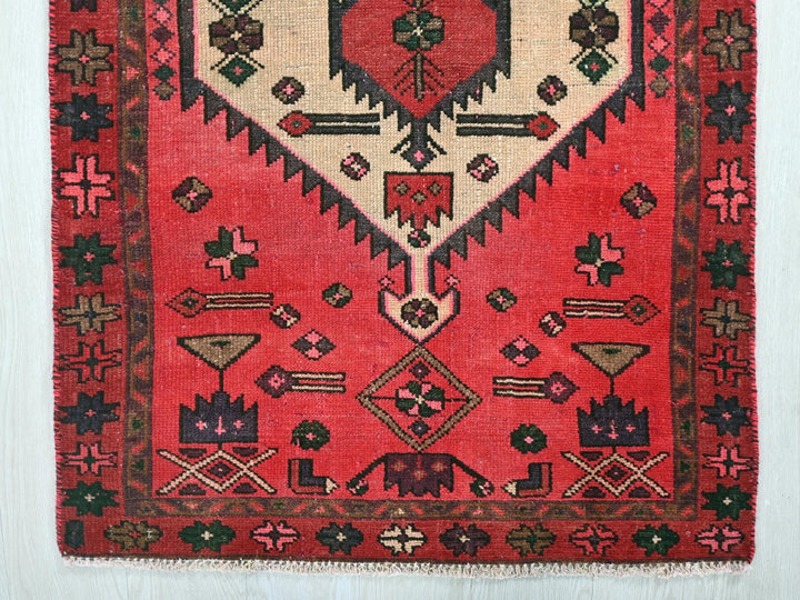 a red rug with a diamond shaped design on it