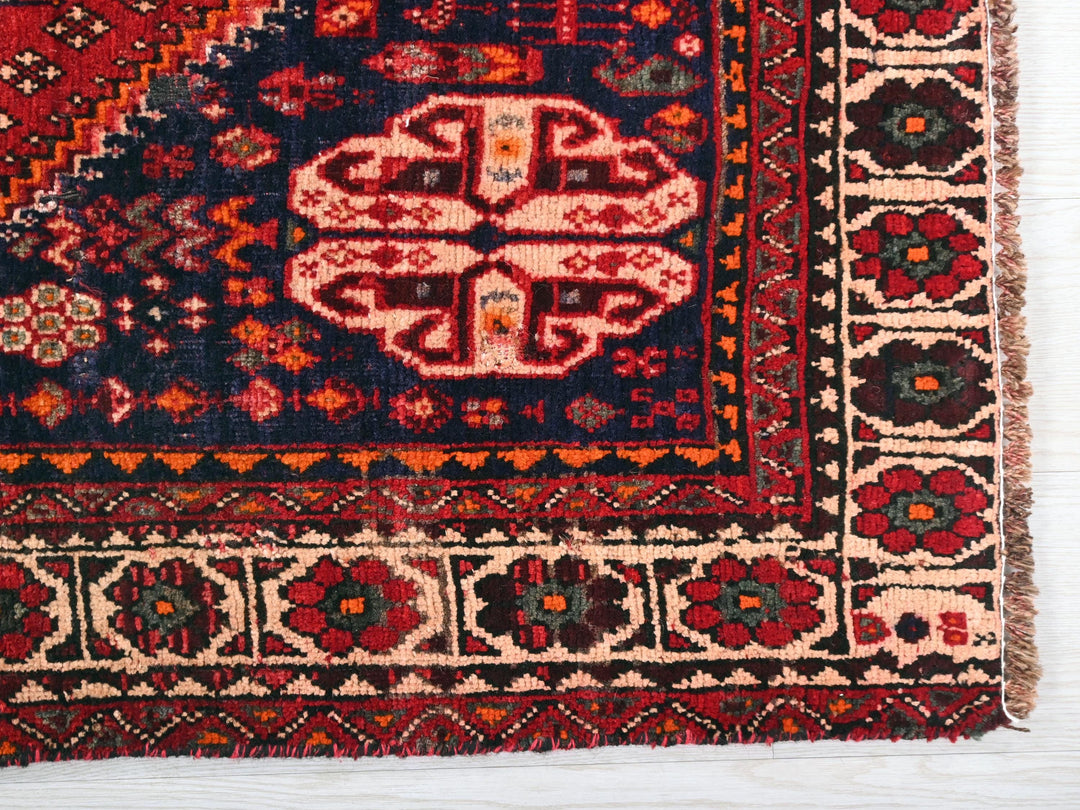 a red and blue rug on a white surface