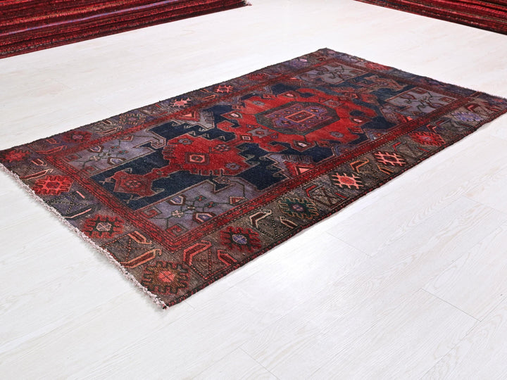 a red and blue rug on a white floor
