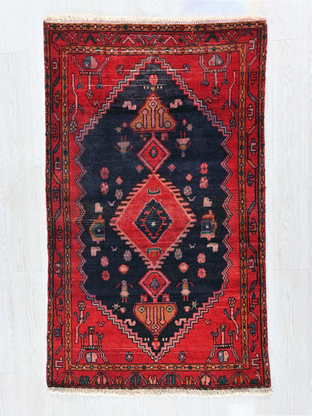 a red and black rug on a wooden floor