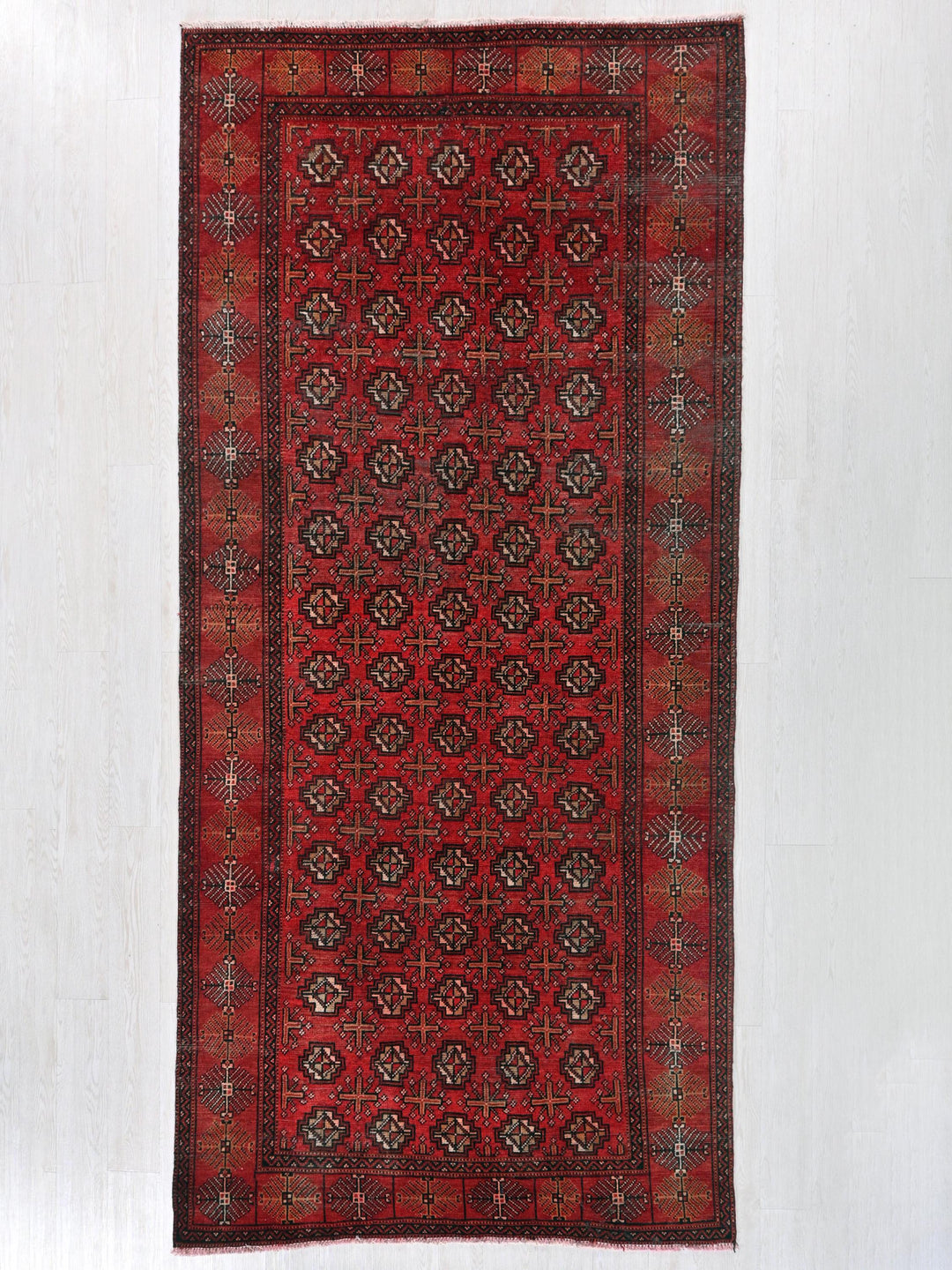 a red rug with a design on the middle of it