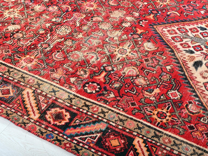 a red oriental rug with a black border