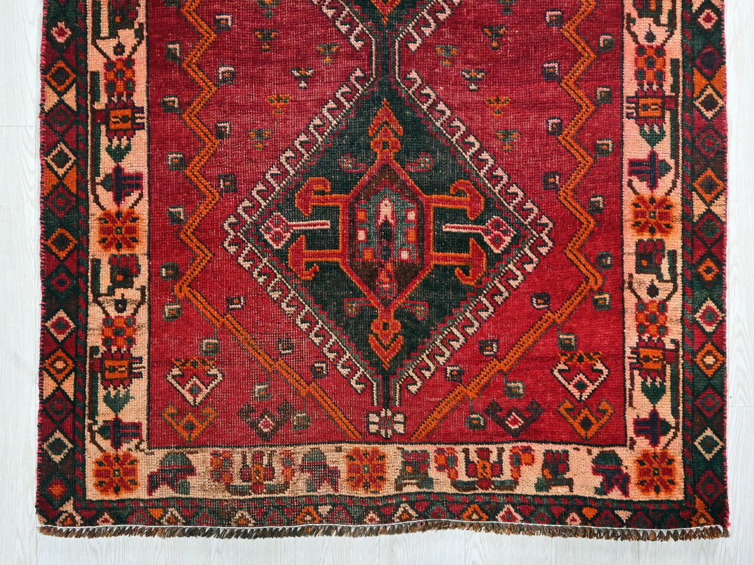 a red rug with a diamond design on it