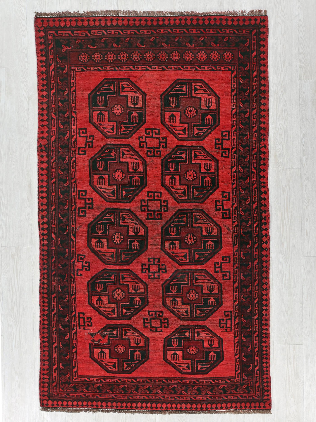 a red rug with a black design on it