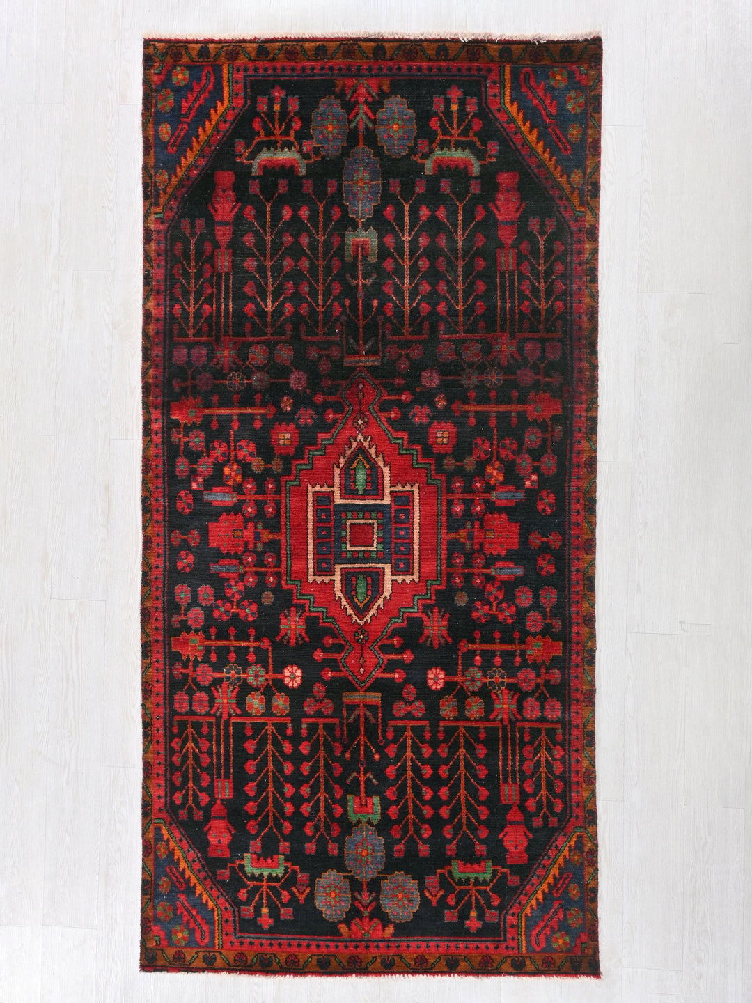 a red and black rug hanging on a wall