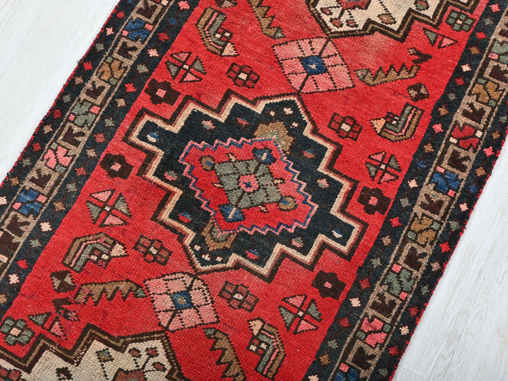 a red rug on a white wooden floor