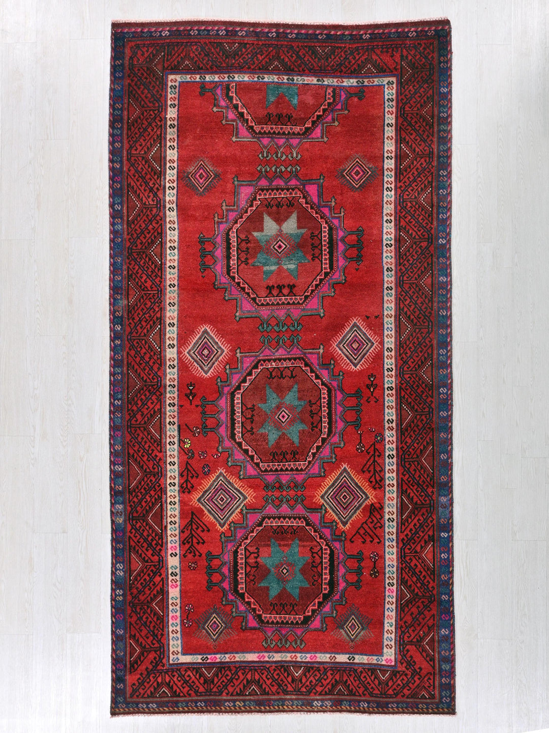 a red rug hanging on a wall