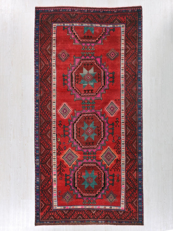 a red rug hanging on a wall