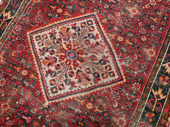 a red oriental rug with an intricate design