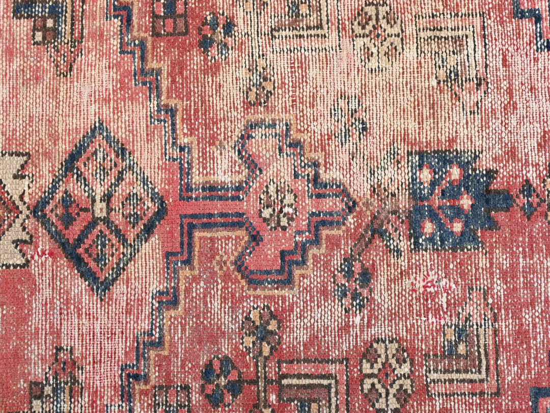 a red rug with blue and white designs on it