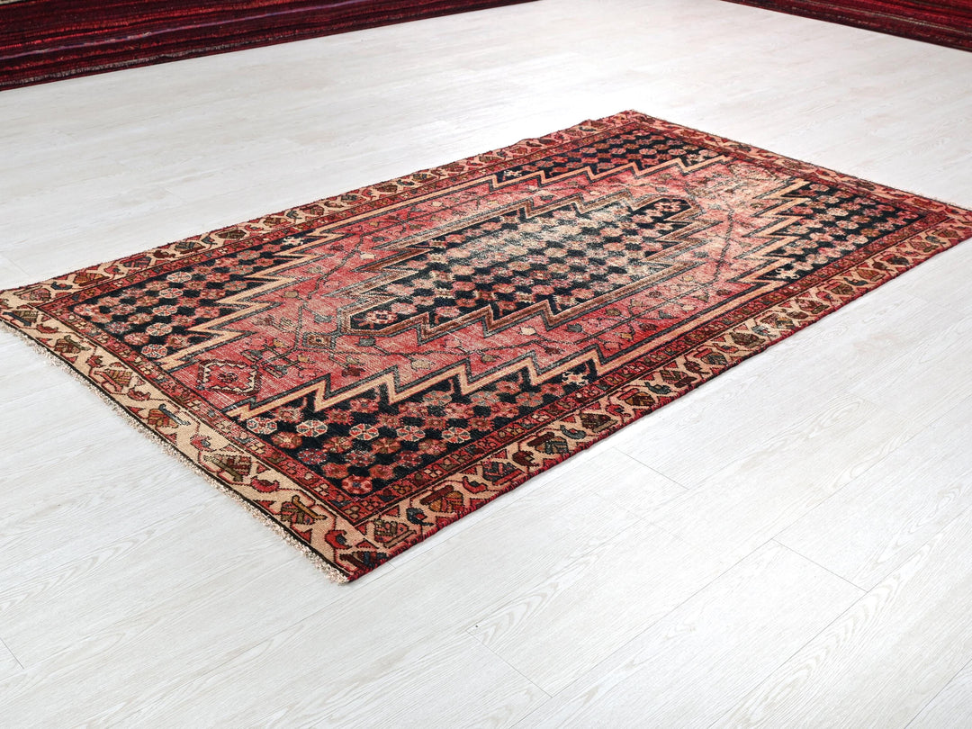a red and black rug on a white floor