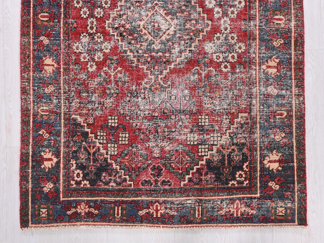 a red and blue rug on a wooden floor