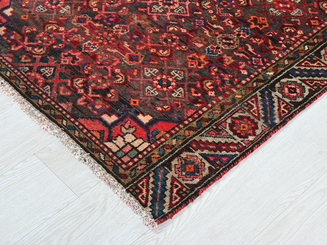 a red and blue oriental rug on a white floor