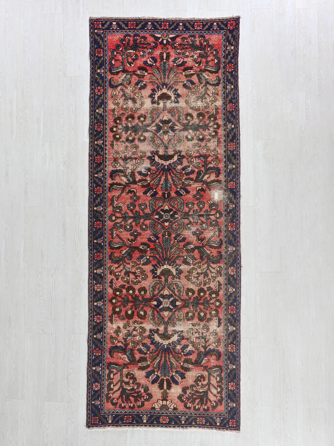 a red and blue rug hanging on a wall