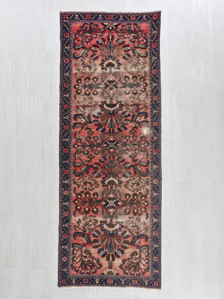 a red and blue rug hanging on a wall