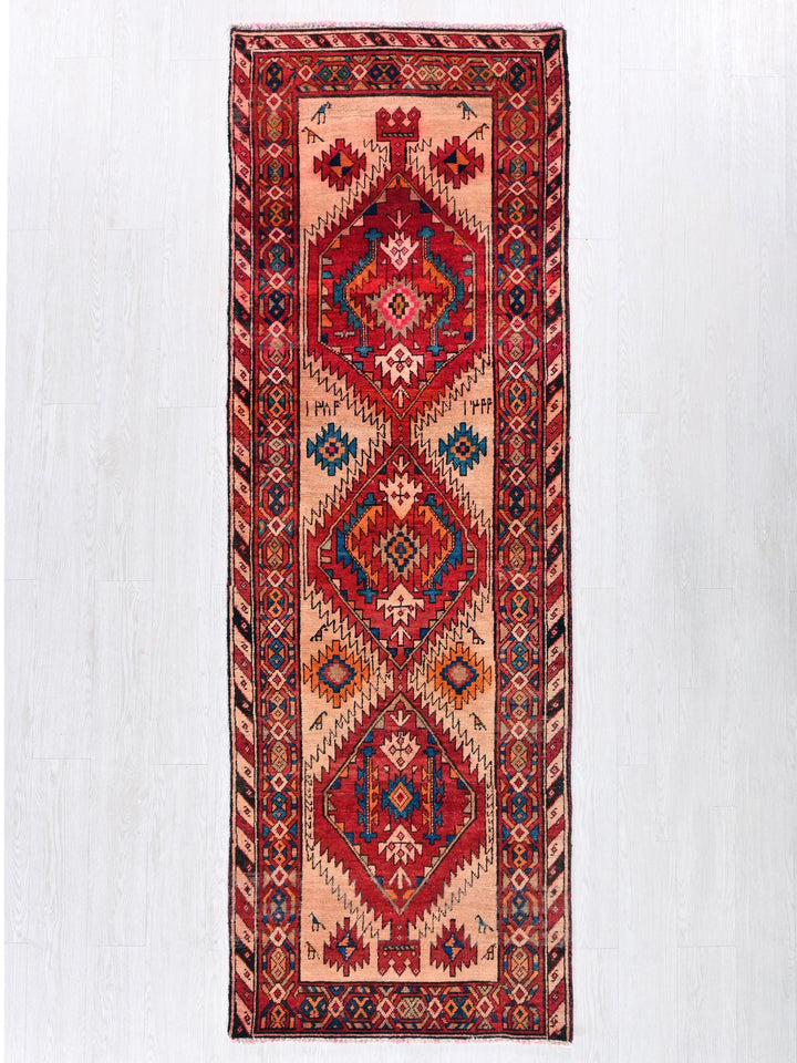 a red and blue rug hanging on a wall