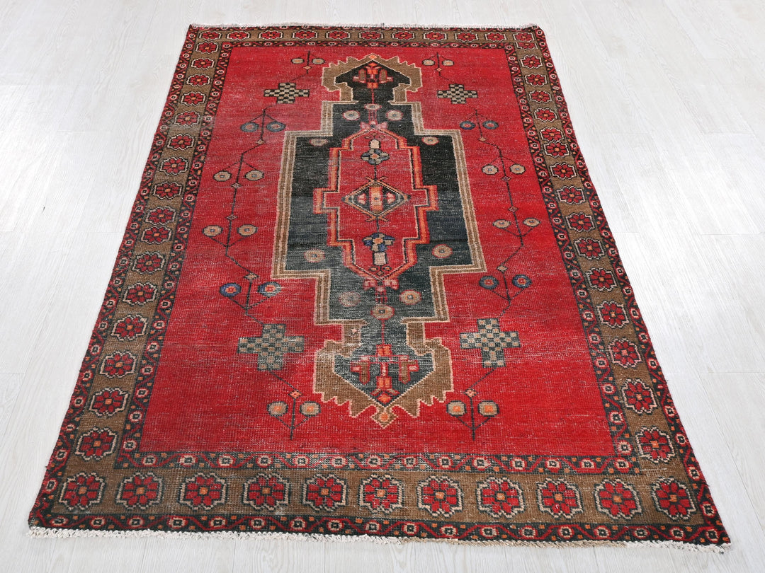 a red rug with a design on the middle of it