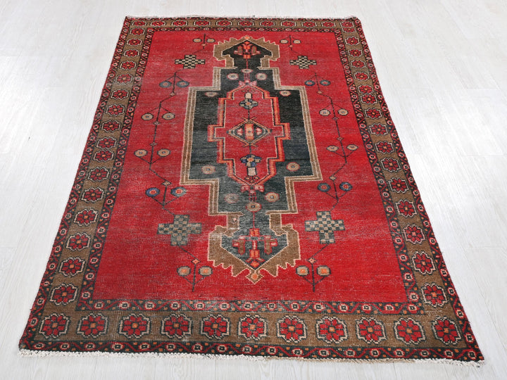 a red rug with a design on the middle of it