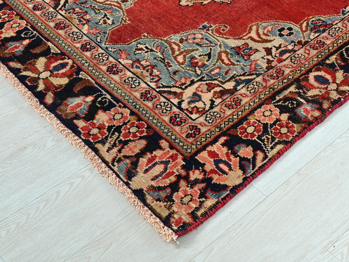 a red rug with a floral design on a white floor