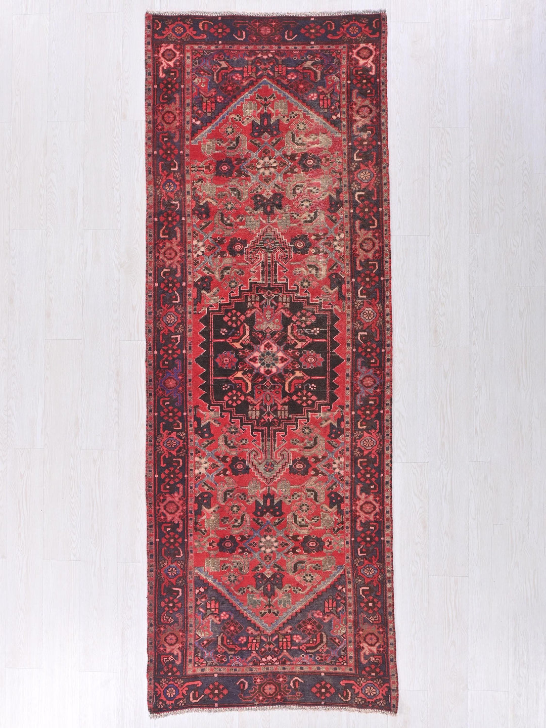 a red rug hanging on a white wall