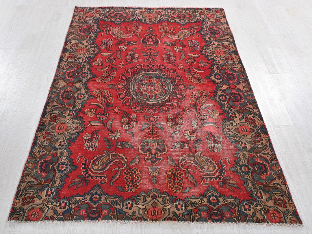 a red rug with a medallion design on a white floor
