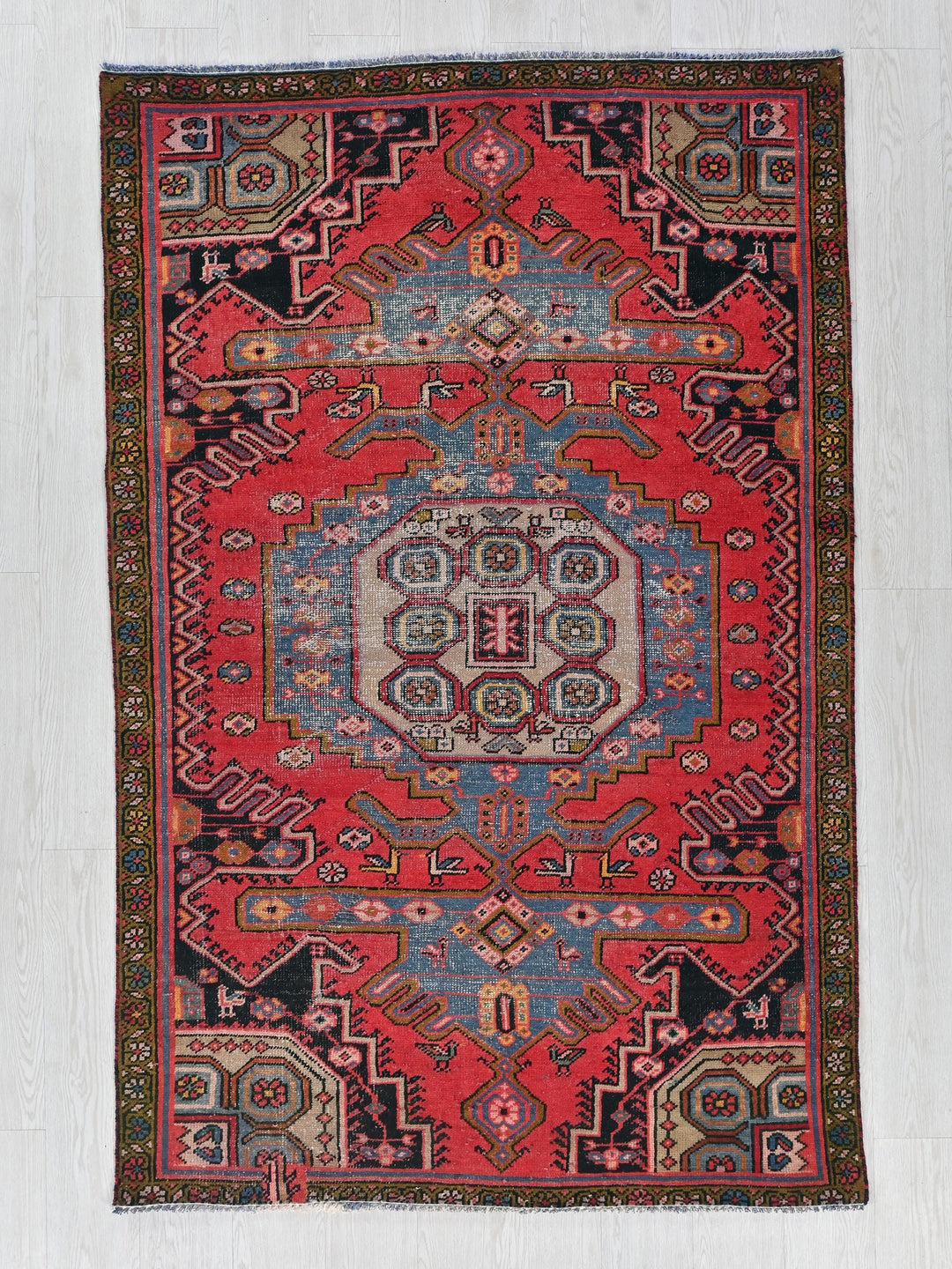 a red and blue rug on a white floor