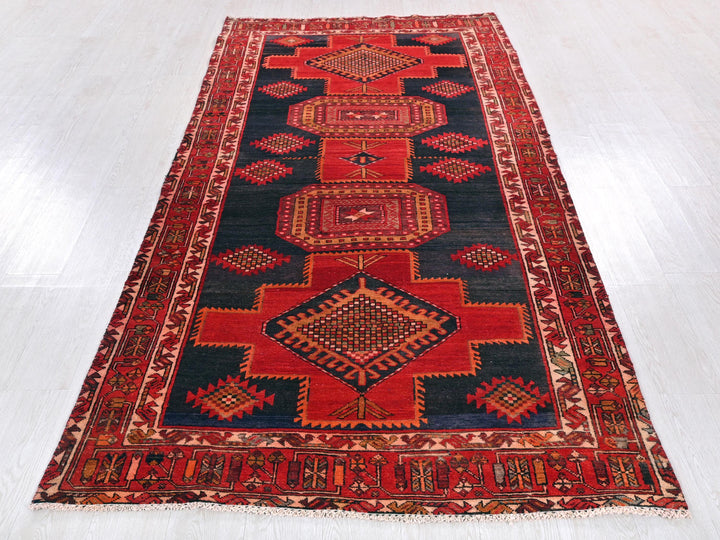 a red and black rug on a white floor