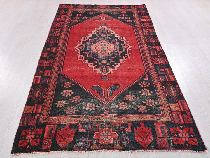 a red and black rug on a white floor