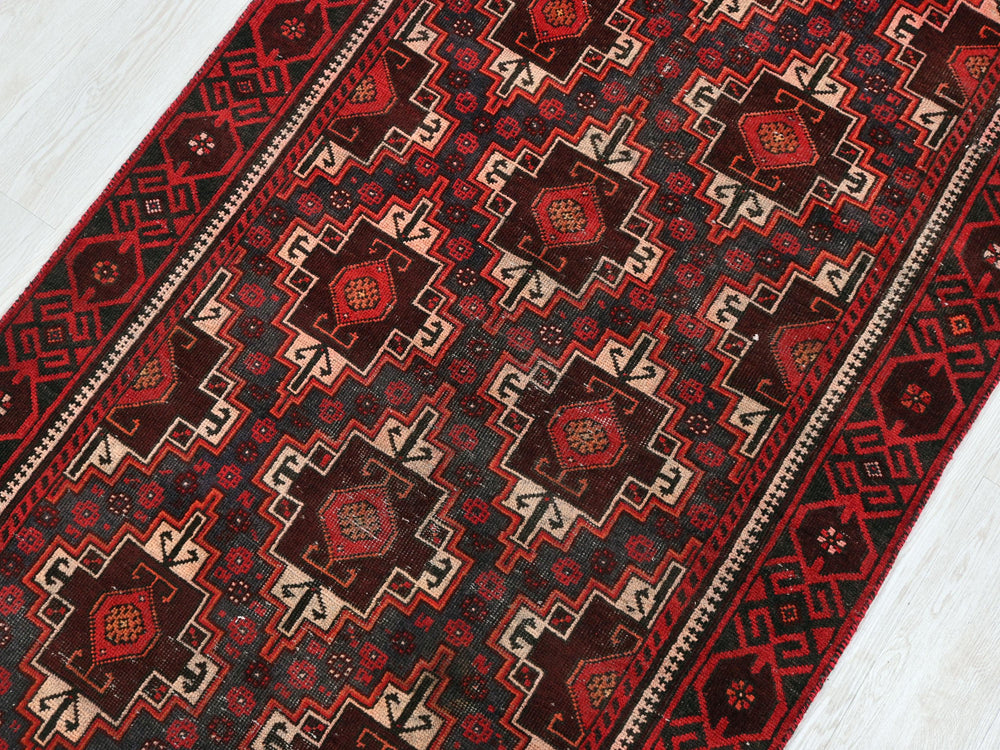 a red and black rug on a white floor
