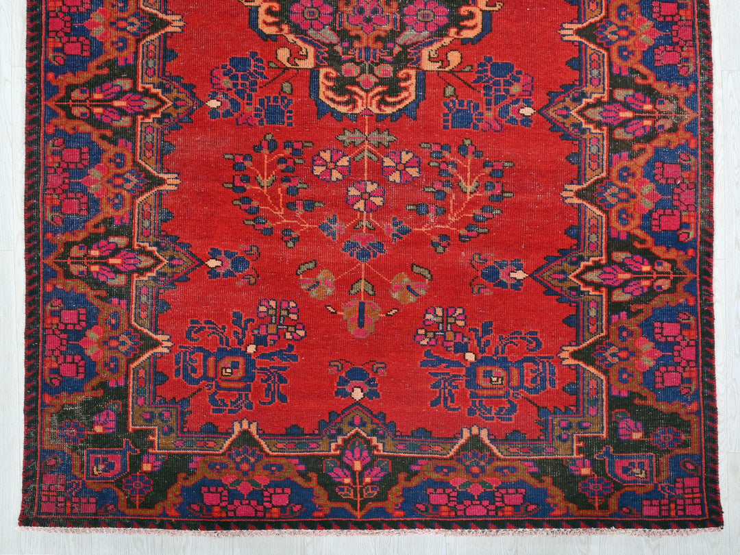 a red rug with a floral design on it