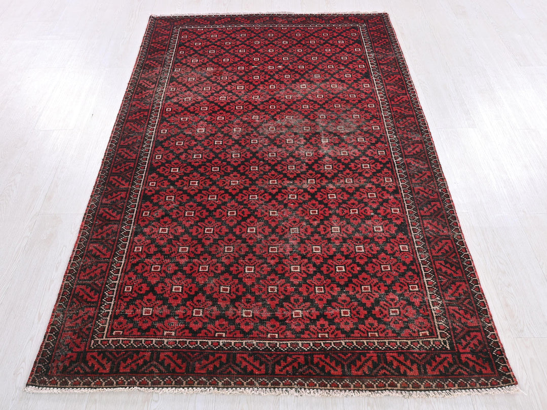 a red and black rug on a white floor