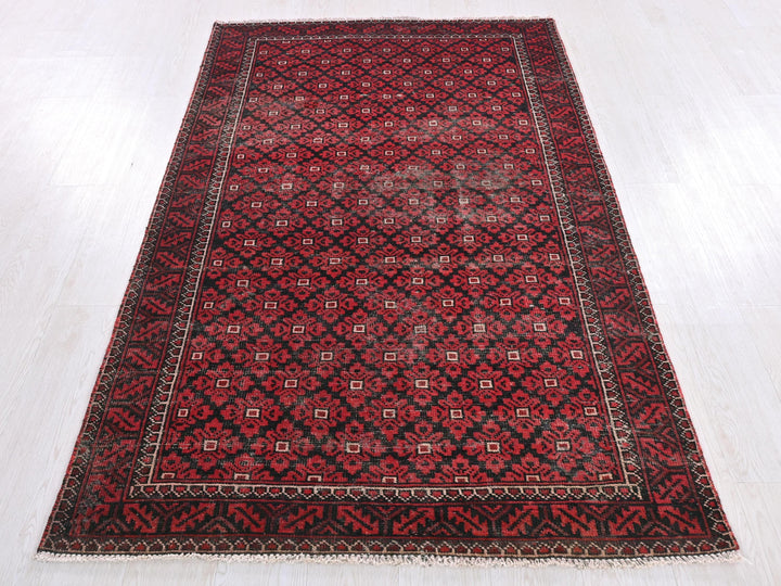 a red and black rug on a white floor