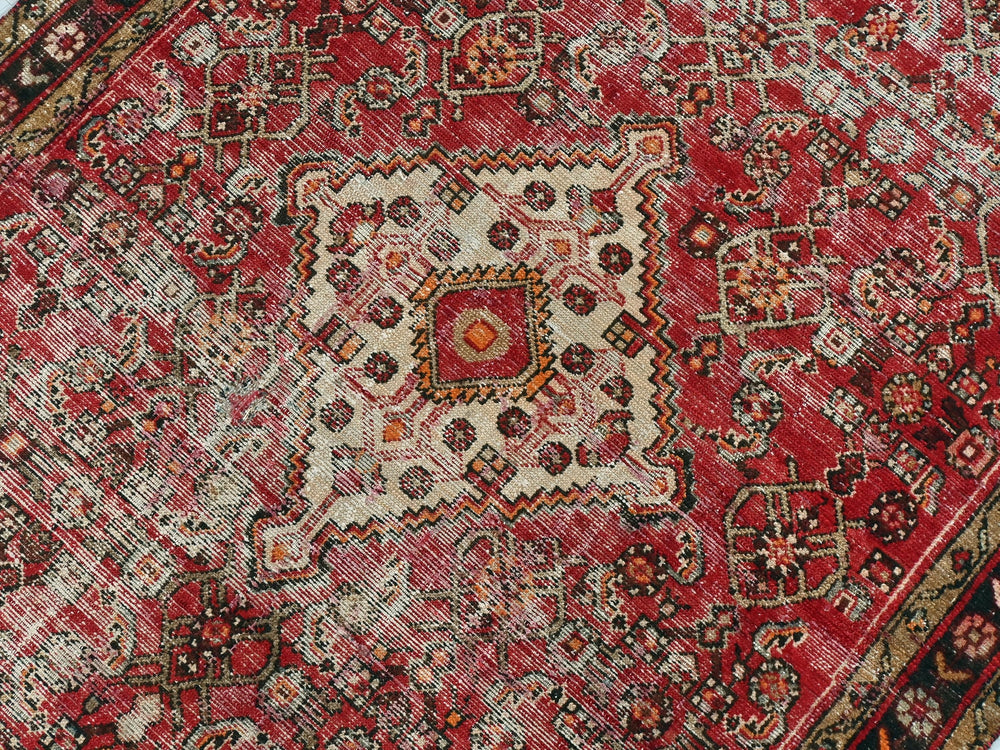 a red oriental rug with an intricate design