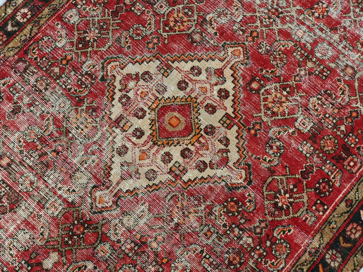 a red oriental rug with an intricate design