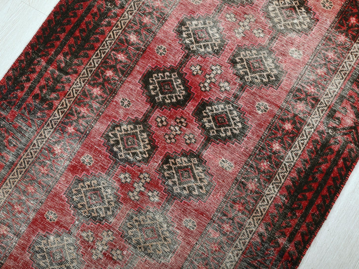 a red rug with a black and white design on it