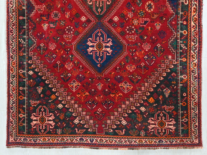 a red rug with a diamond shaped design