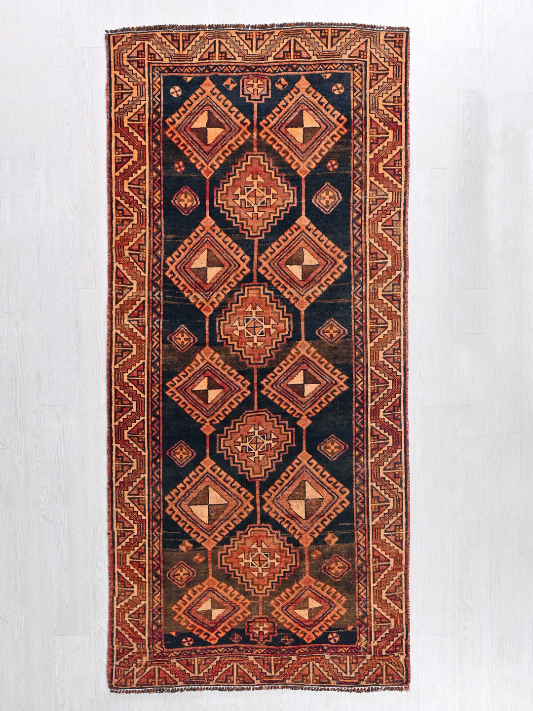 a red and black rug hanging on a wall