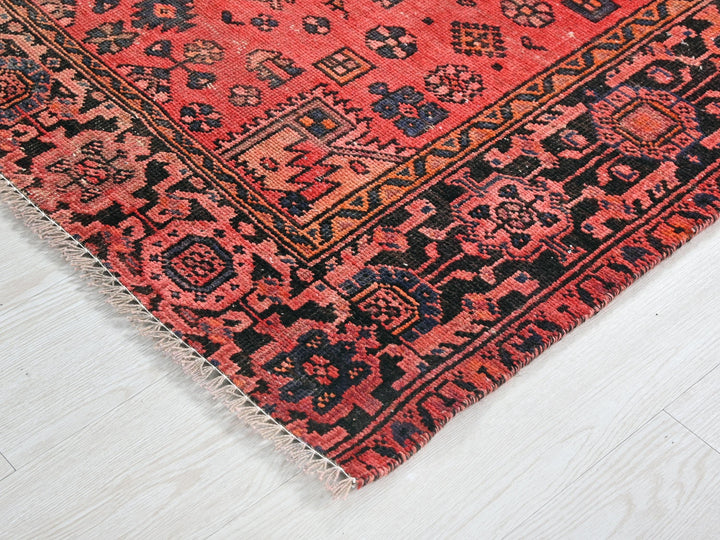 a red and black rug on a white floor