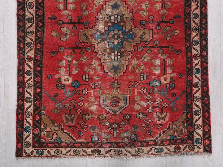 a red rug with a blue and brown design on it