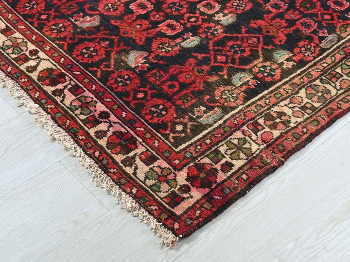 a red and black oriental rug on a white floor