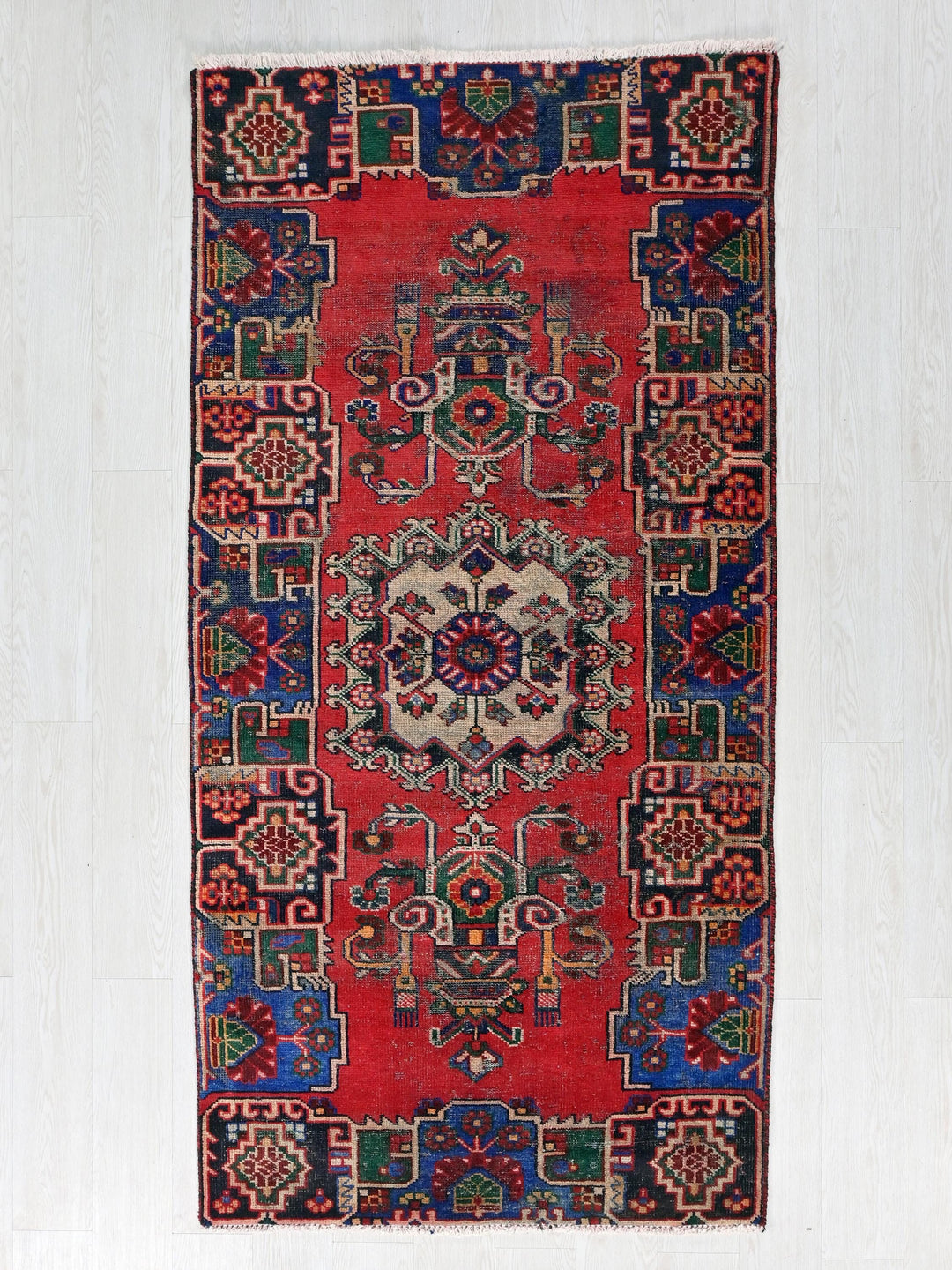 a red and blue rug hanging on a wall