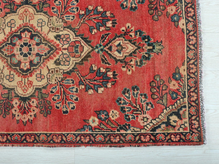 a red rug with a floral design on it