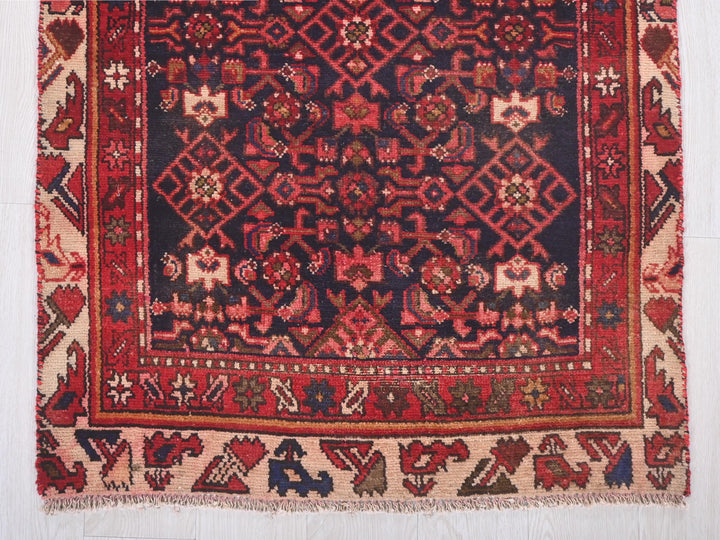 a red and black rug on a white floor