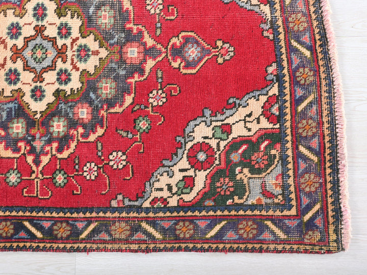 a red rug with a floral design on it