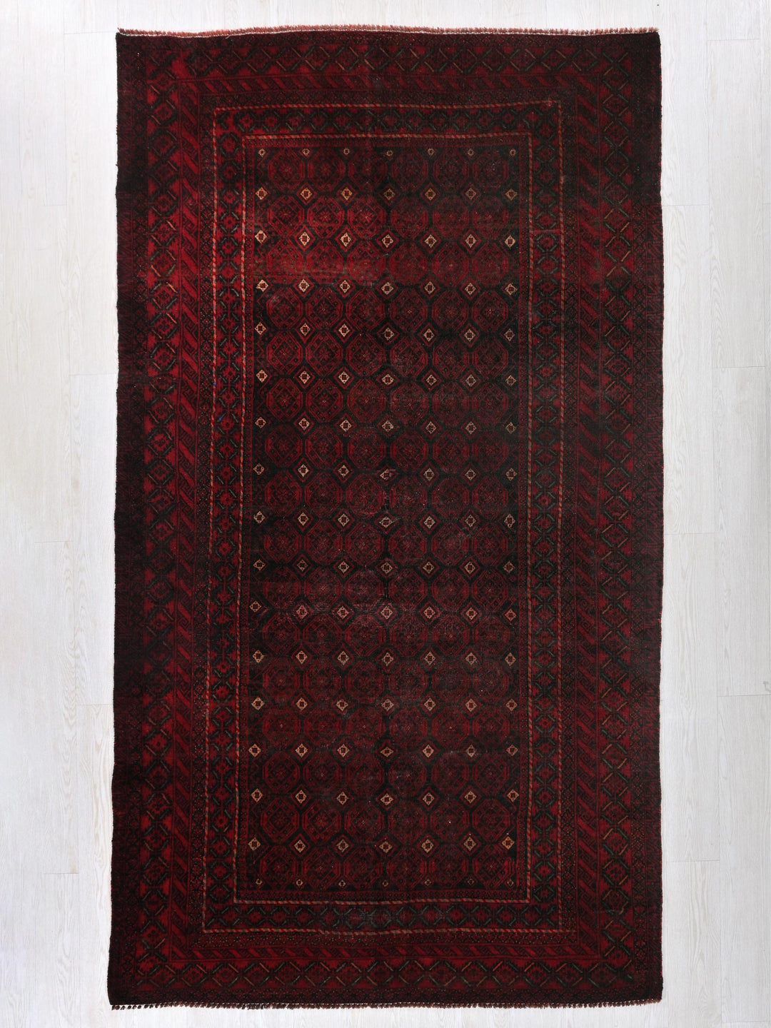 a red and black rug on a white floor