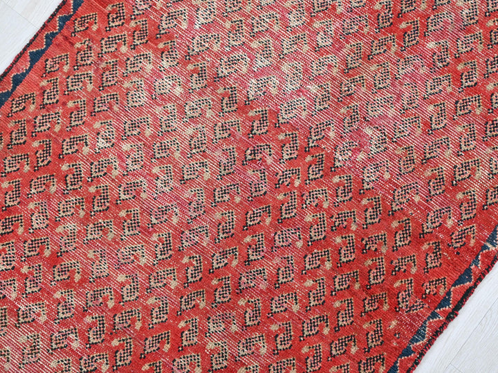 a red and blue rug on a white floor