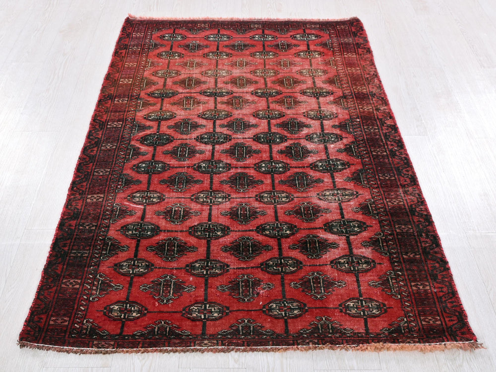 a red and black rug on a white floor